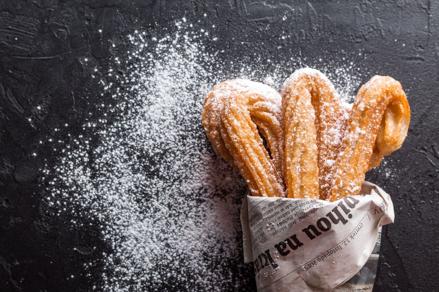 Unos churros con azúcar glasé / PEXELS