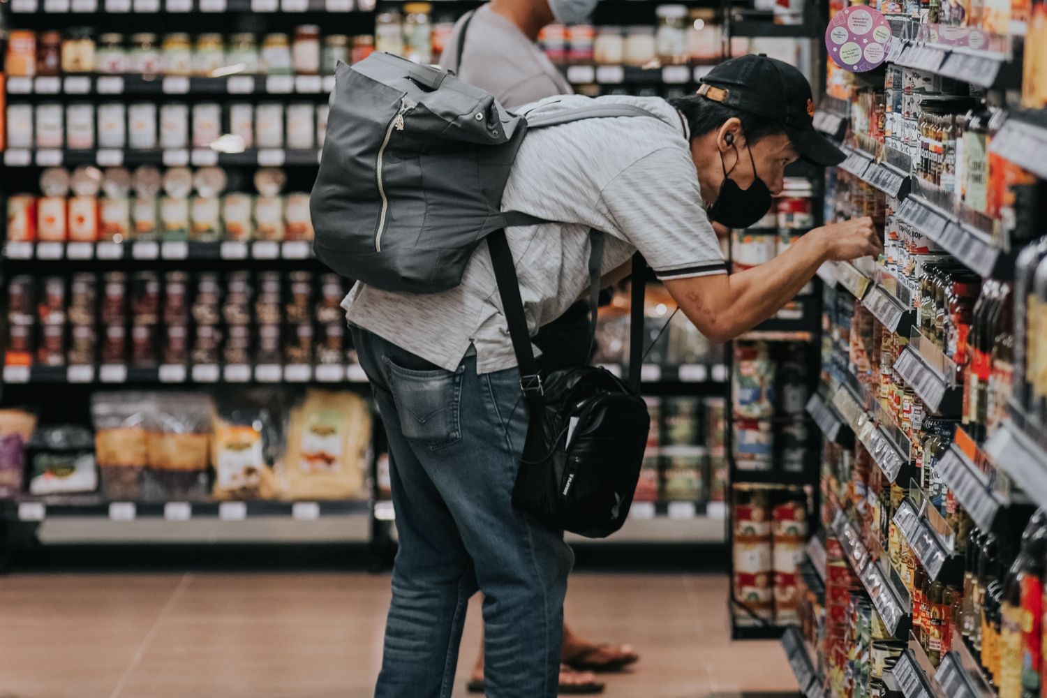 Un consumidor mira el precio en un supermercado antes de comprar / UNSPLASH