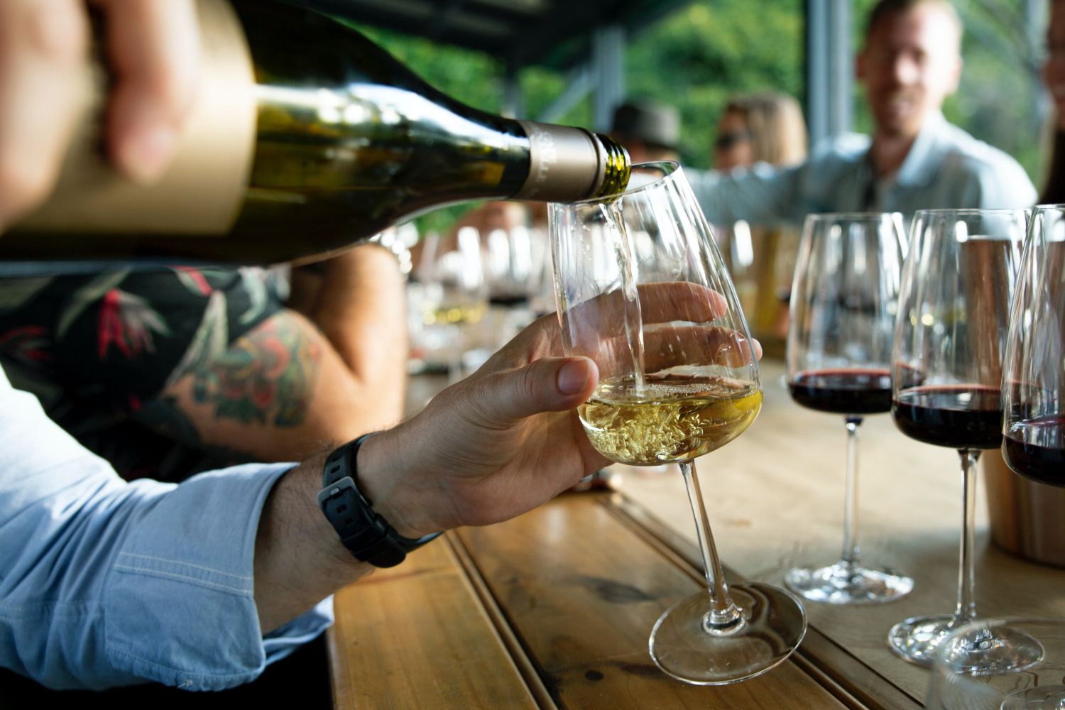 Una persona sirve una copa de vino en una bodega / UNSPLASH