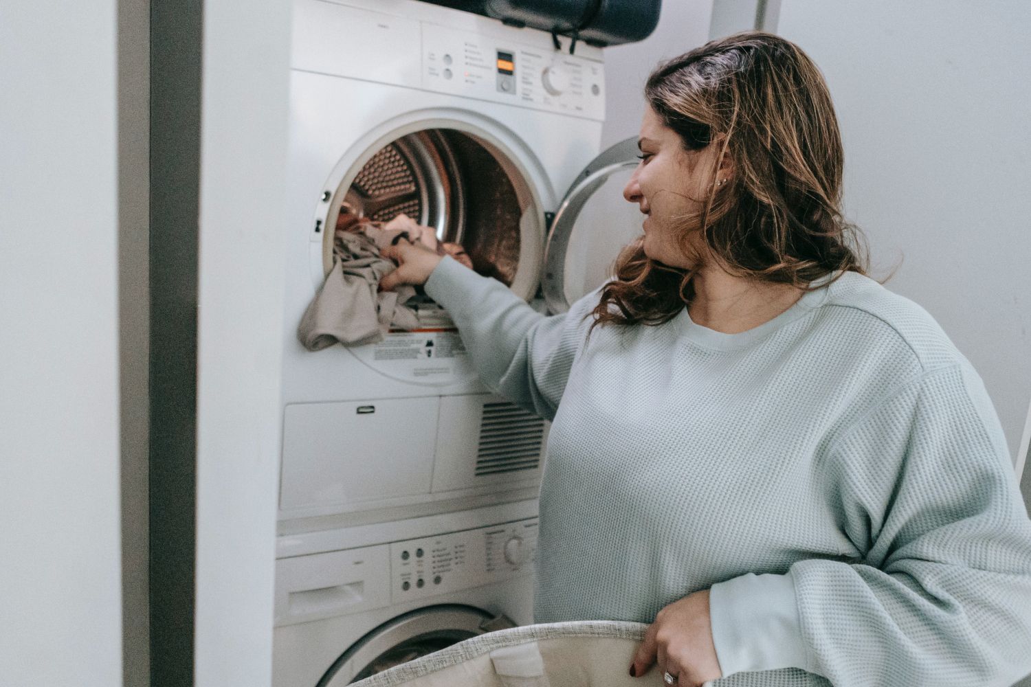 Una mujer pone una lavadora en la franja más barata del precio de la luz / PEXELS