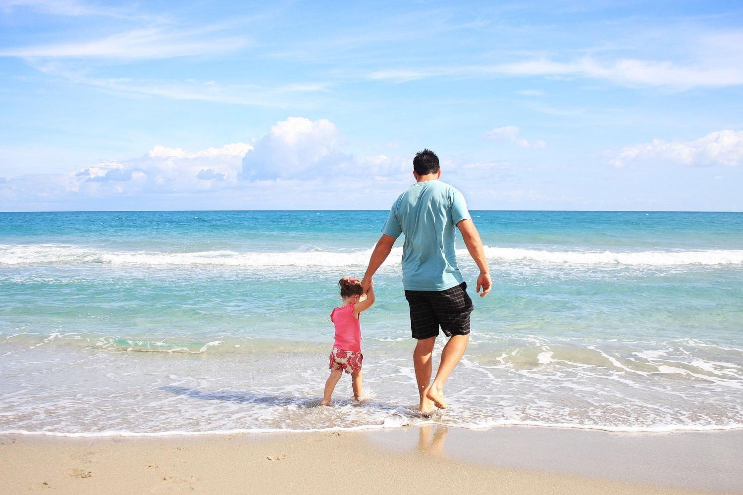 Un padre con su hija en la playa en verano / PIXABAY