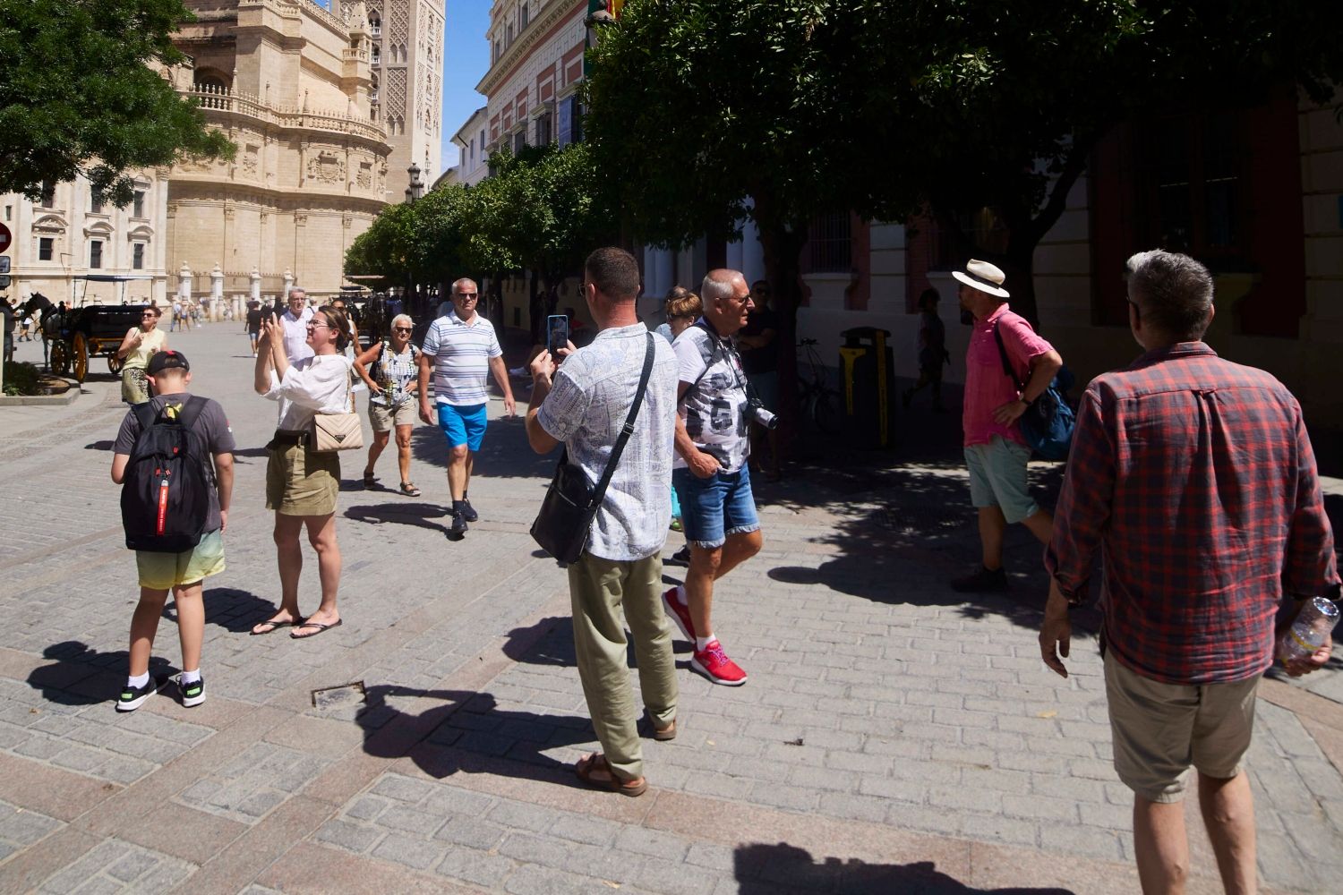 Varios turistas pasean y hacen fotos en Sevilla, uno de los destinos españoles más populares  / EP