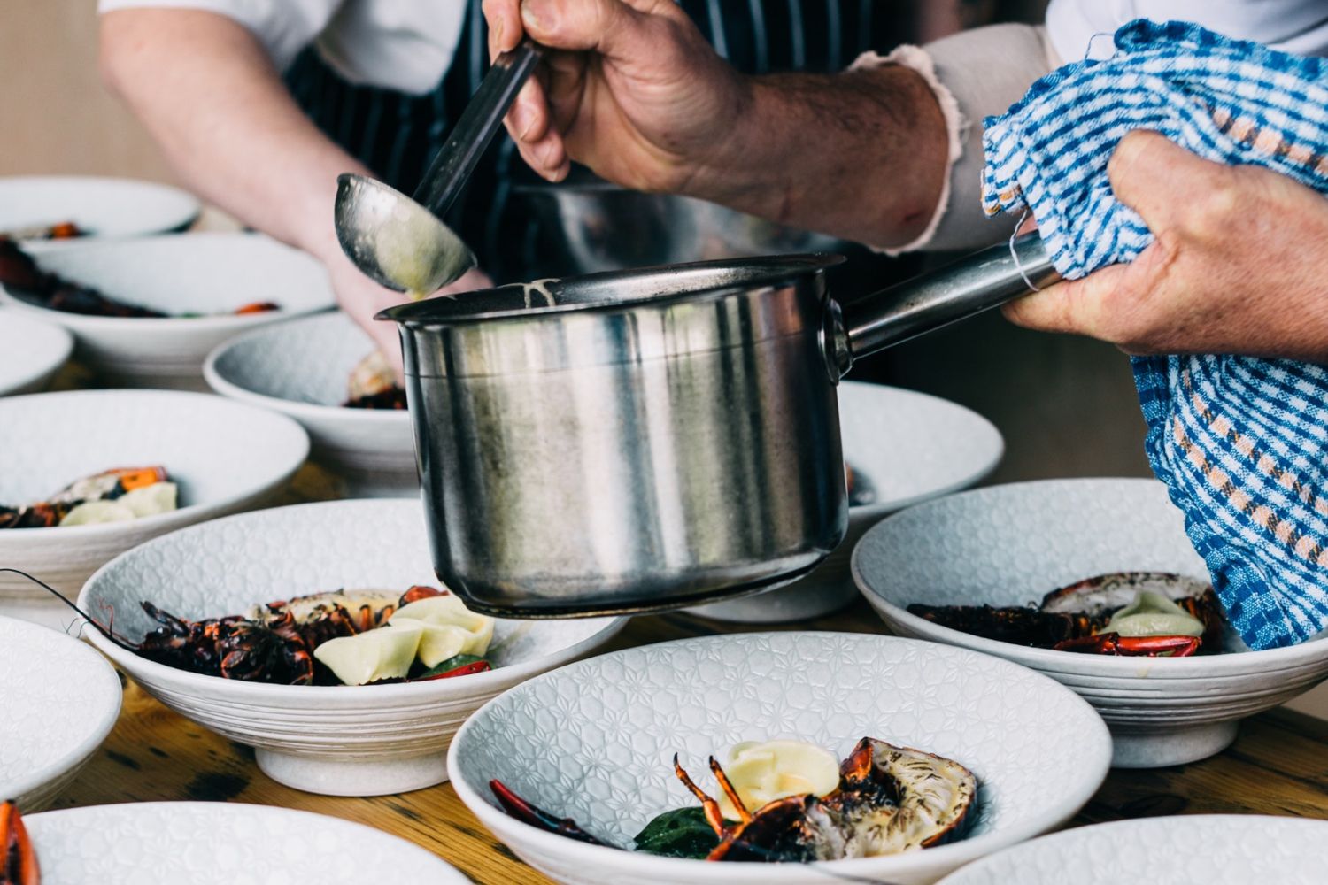 Un chef emplata un plato de pescado en un restaurante/ PEXELS