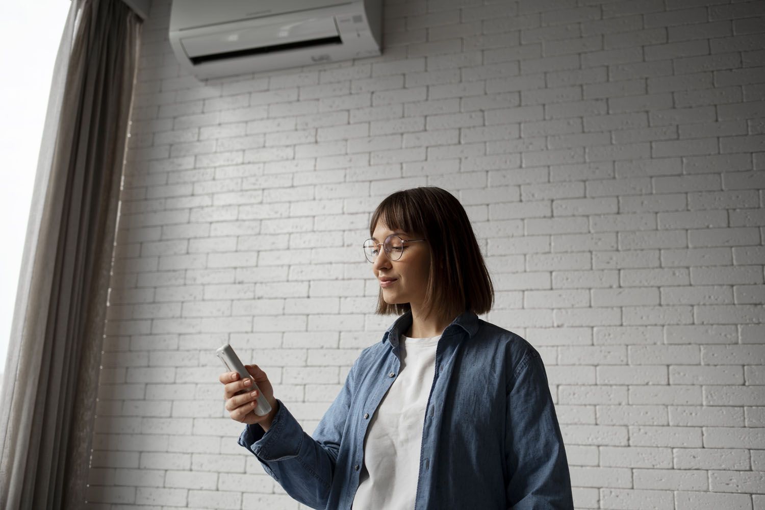 Una mujer se plantea si poner el aire acondicionado debido al alto precio de la luz / FREEPIK