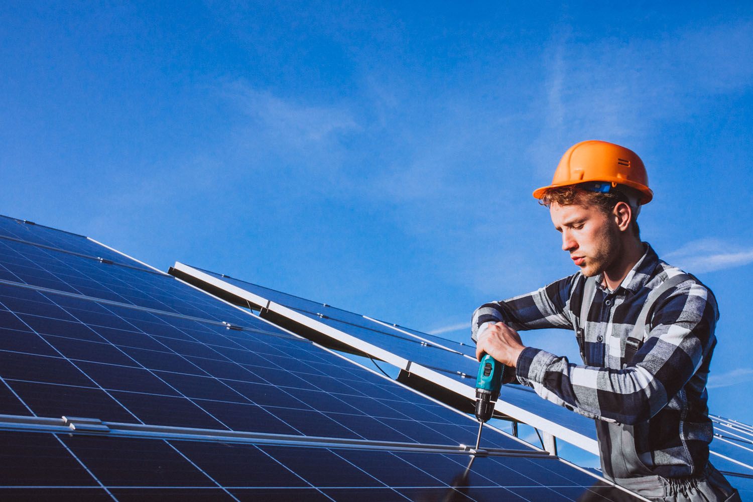 Un hombre instala placas solares para evitar el alto precio de la luz / FREEPIK