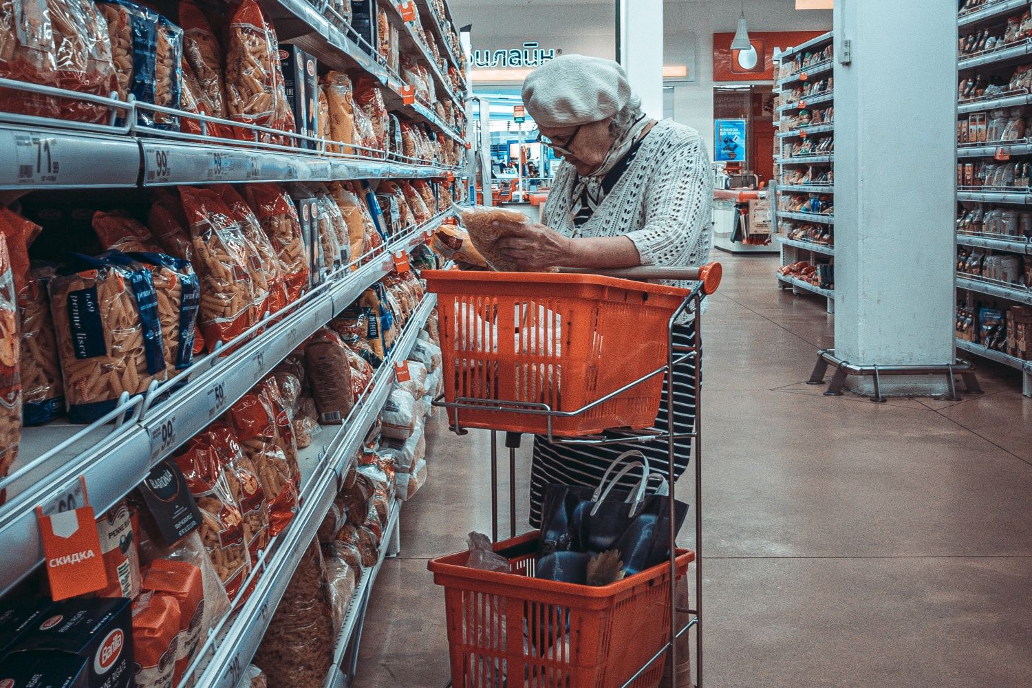 Una señora con una cesta de la compra en un supermercado / PEXELS