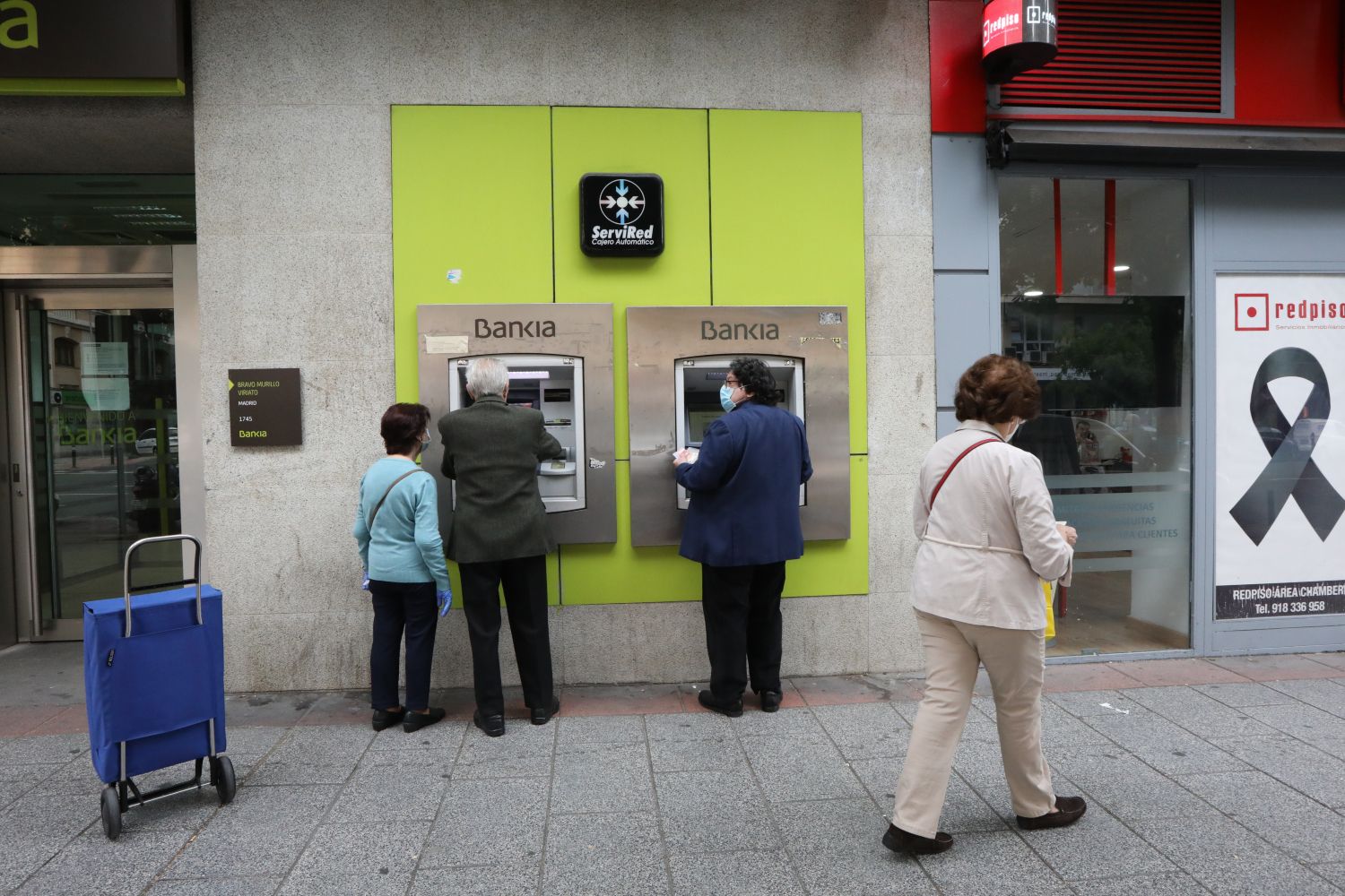 Varias personas mayores sacan el dinero de sus pensiones del cajero / EUROPA PRESS - MARTA FERNÁNDEZ