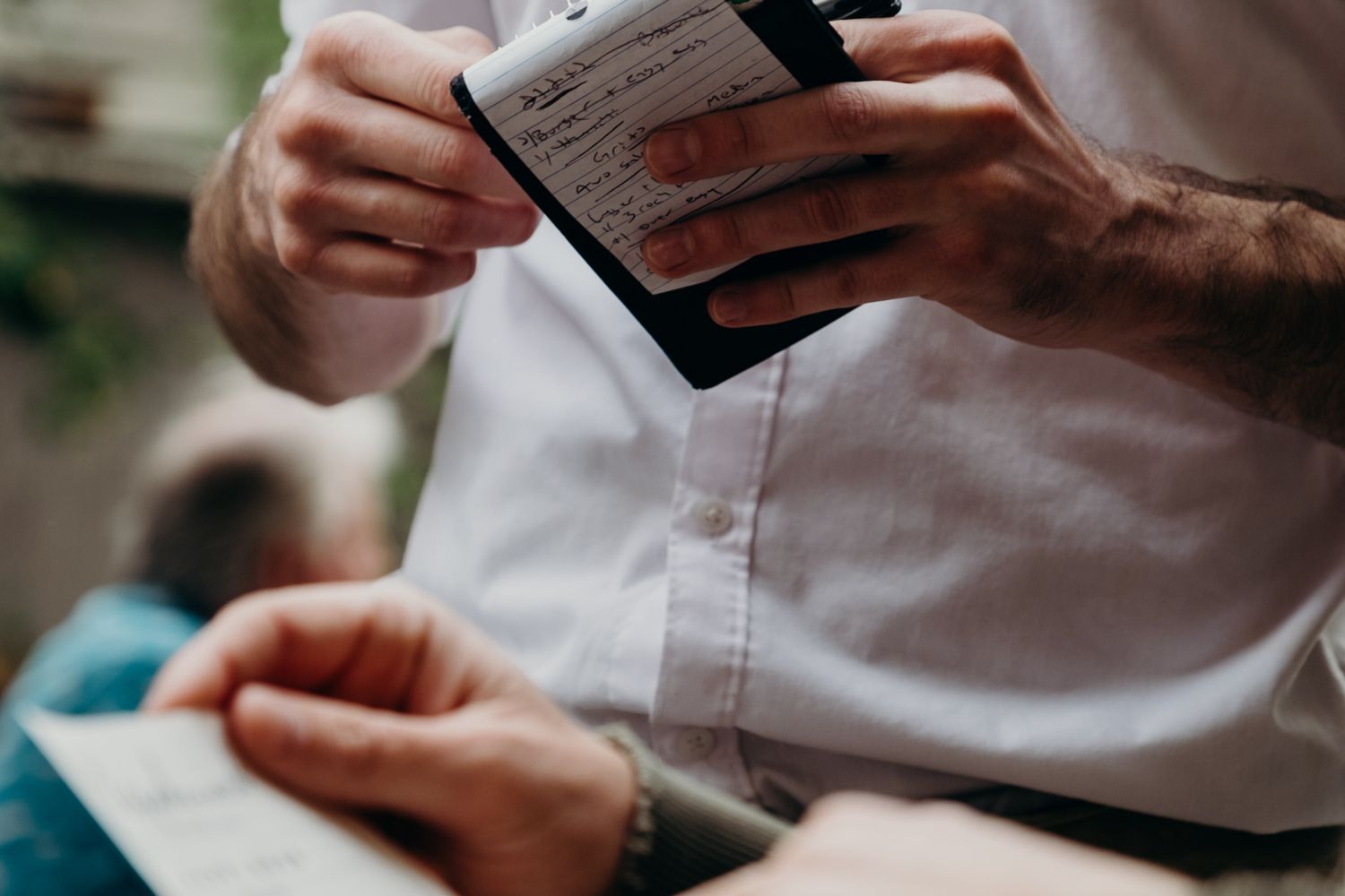 Un comensal revisa la cuenta de una comida delante del camarero / UNSPLASH