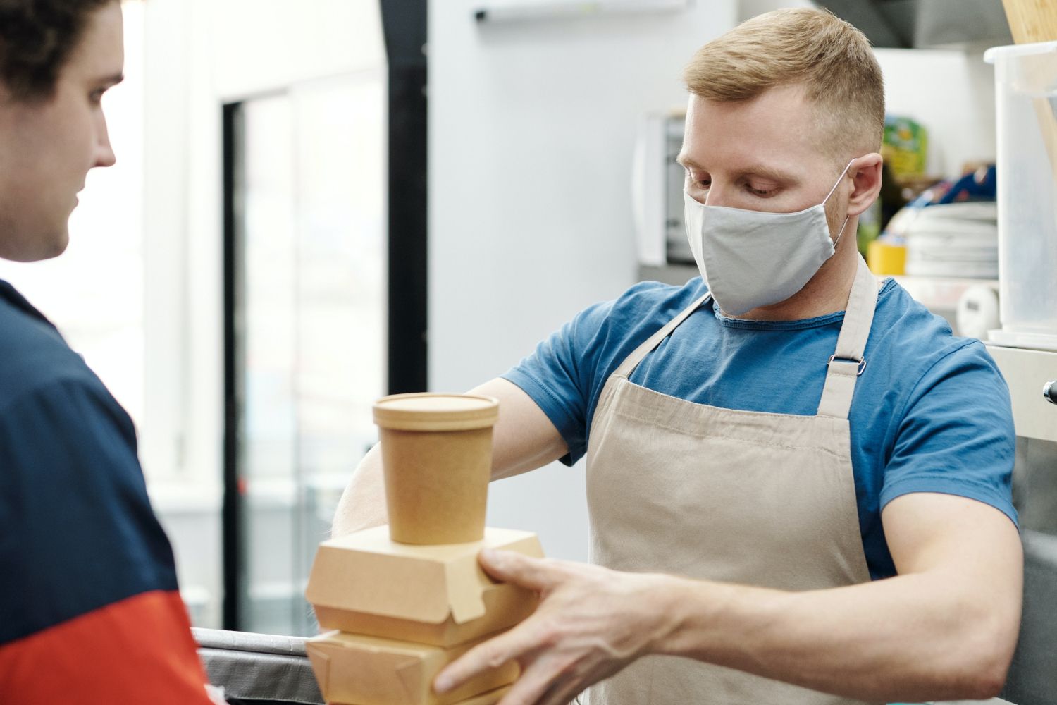 Un cocinero ofrece a un cliente un túper en el que llevarse las sobras / UNSPLASH