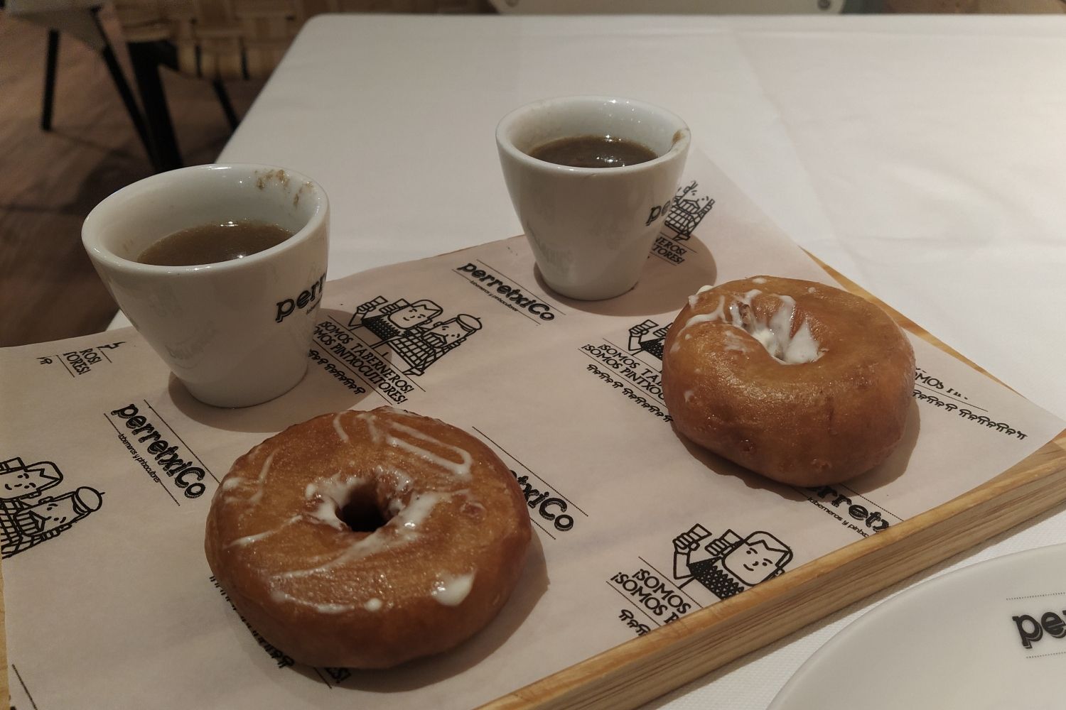 Dos dónuts de cocido servidos con dos tazas de caldo / CG