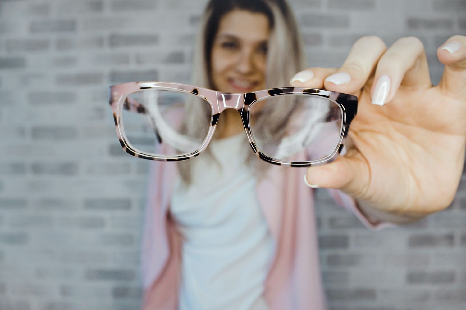 Una mujer muestra sus gafas / PEXELS