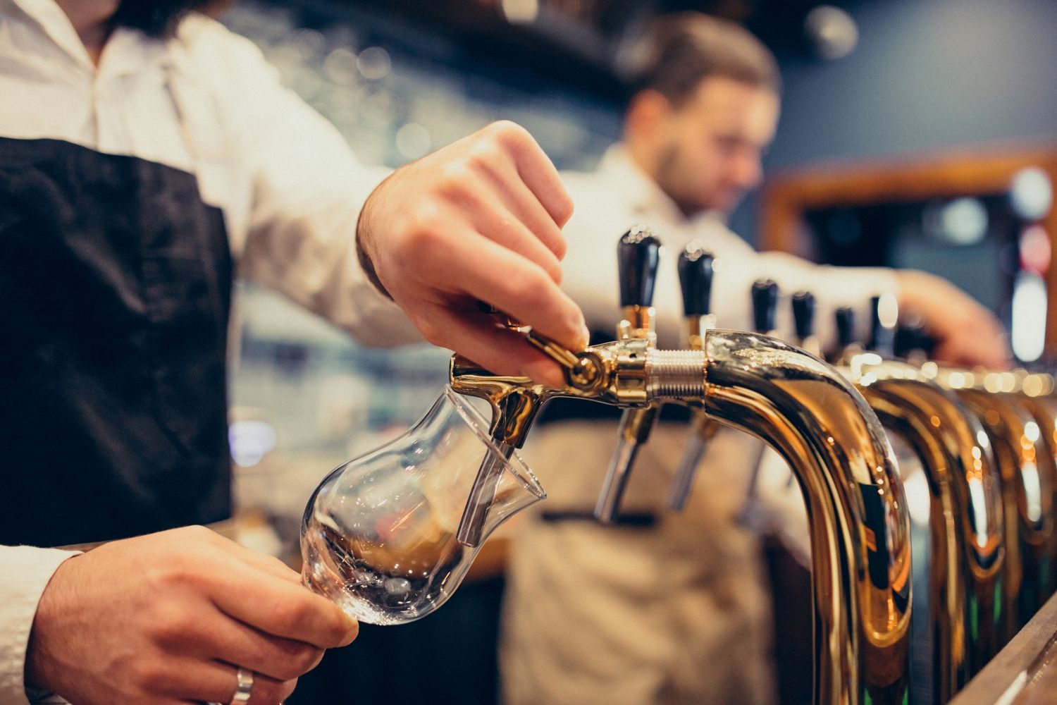 Un camarero sirviendo una cerveza en un bar / FREEPIK