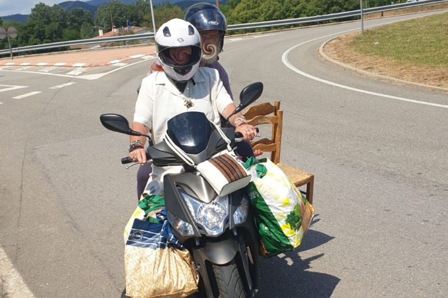 Denuncian al conductor de esta motocicleta por llevar dos sillas y bolsas enormes en la carretera / TWITTER MOSSOS