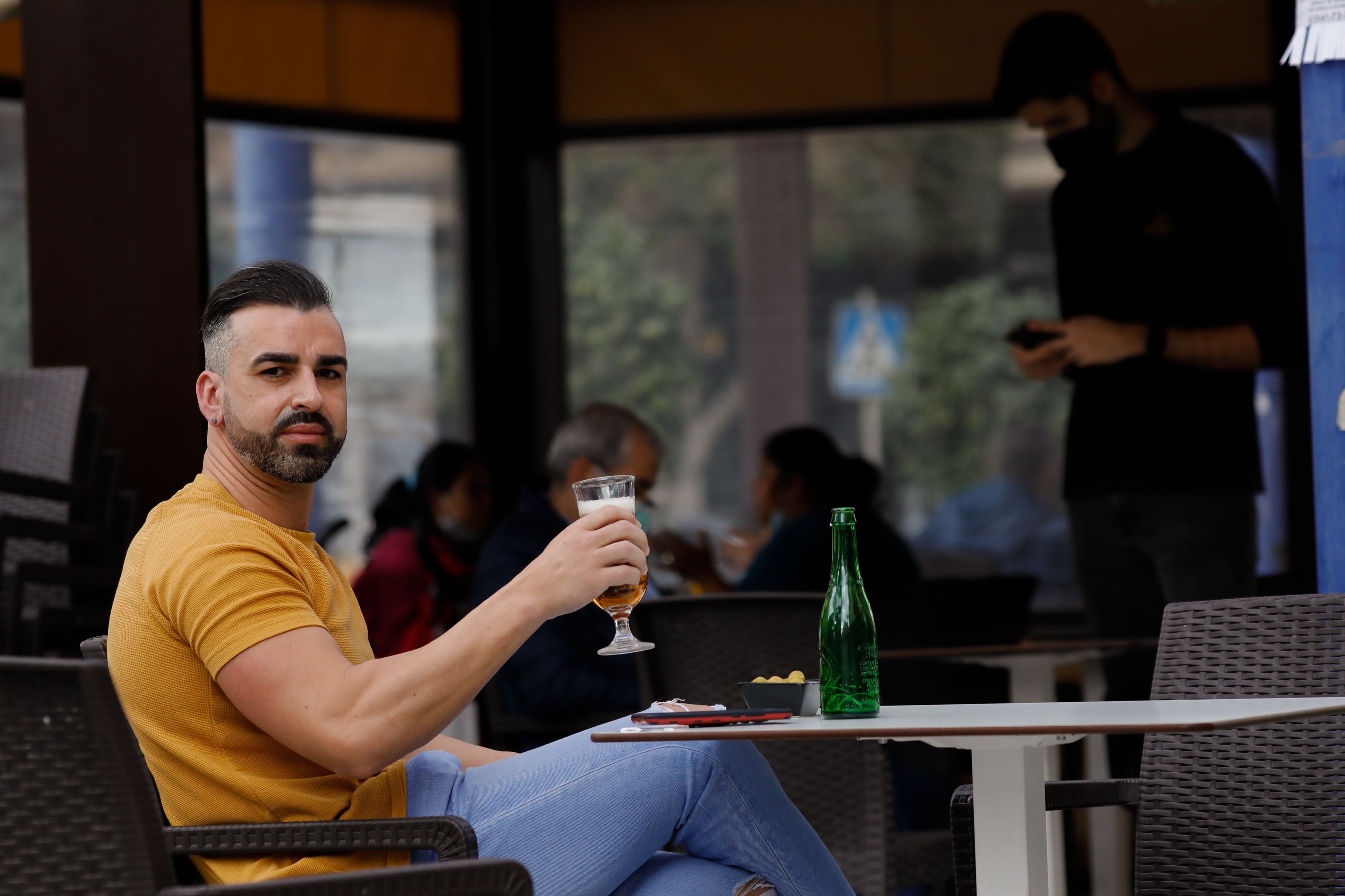 Un hombre se toma una cerveza en la terraza de un bar / EP