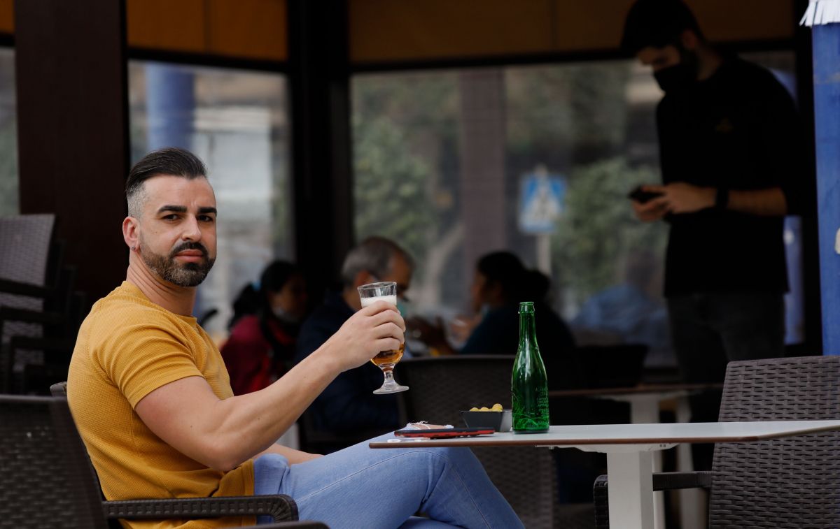 Un hombre se toma una cerveza en la terraza de un bar / EP
