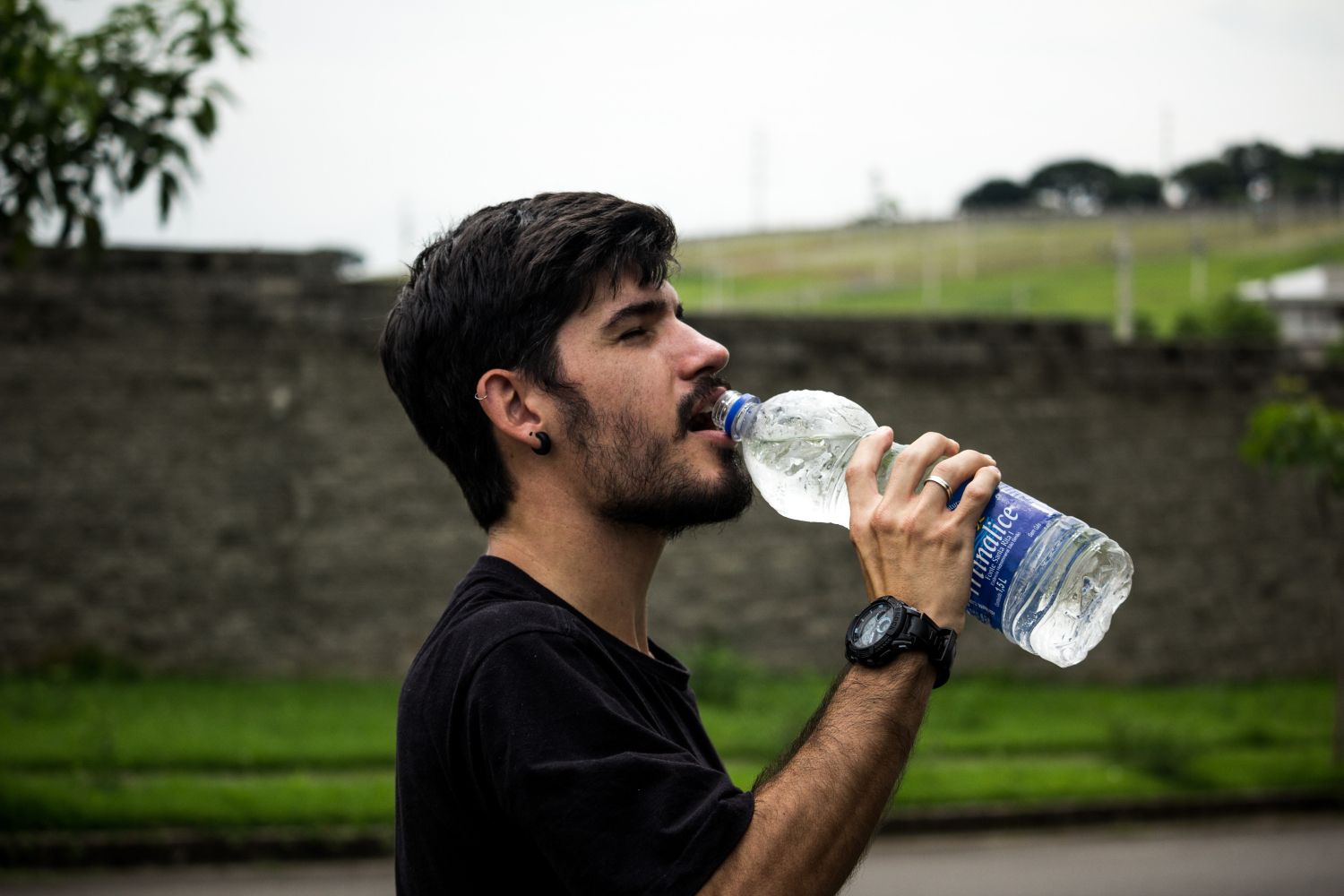 Una persona con una botella de agua embotellada / PEXELS