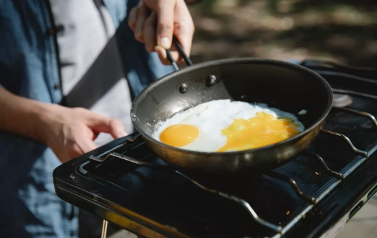 Una persona fríe huevos en una sartén / PEXELS