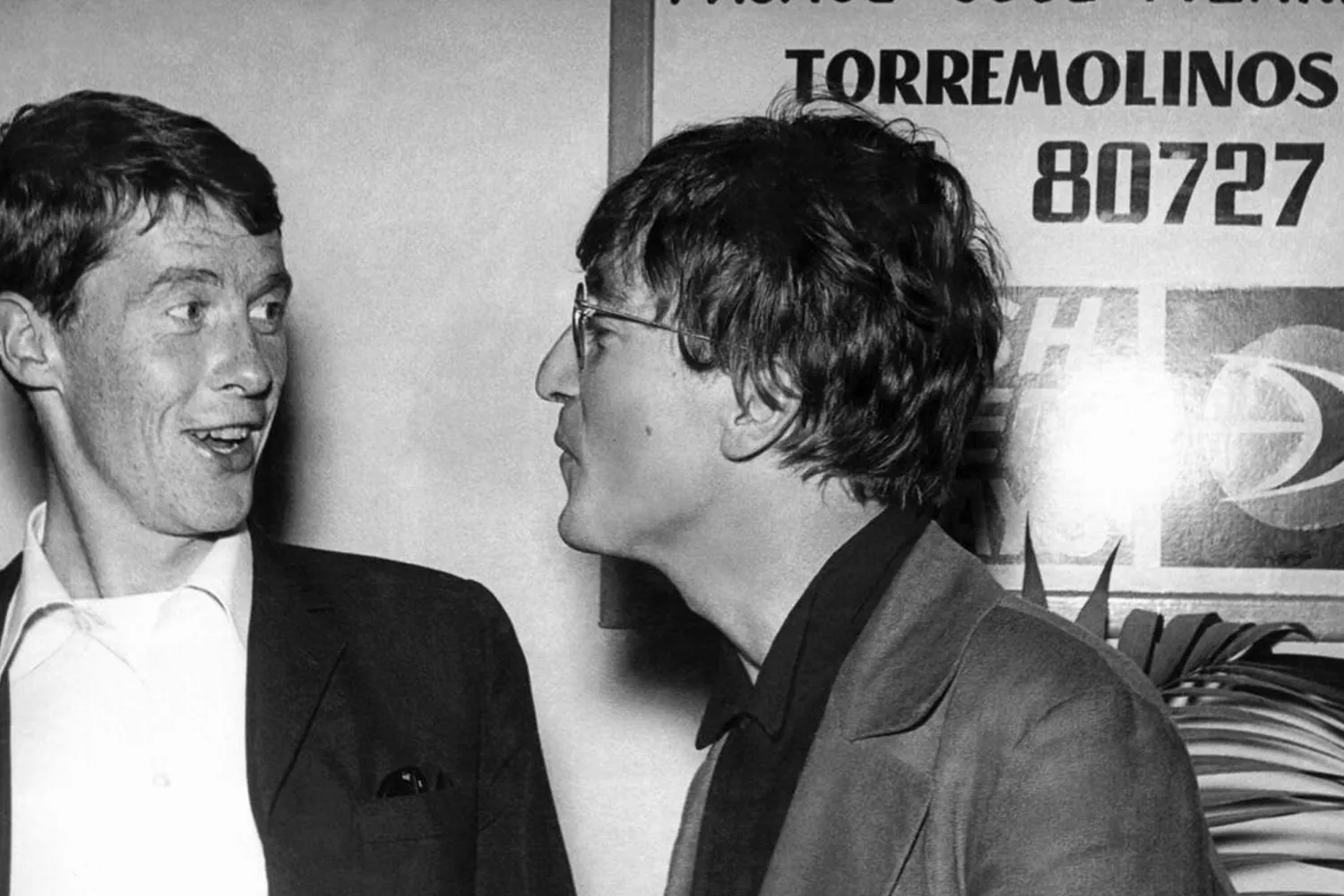 John Lennon, derecha, junto al actor Michael Crawford, ante un cartel del pasaje José Pizarro de Torremolinos, en el aeropuerto de Málaga / EFE