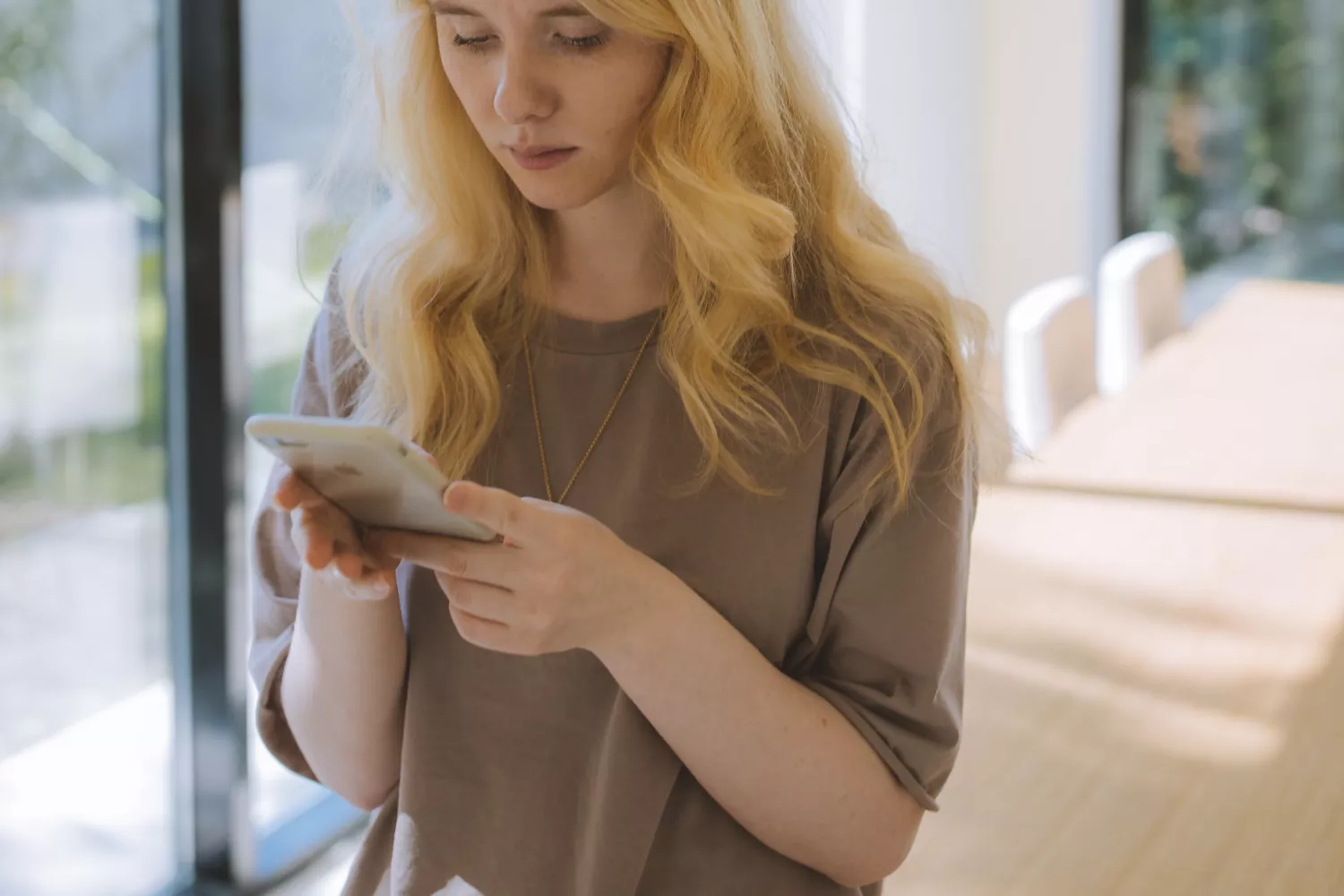 Una mujer comprueba un número sospechoso en su iPhone / PEXELS