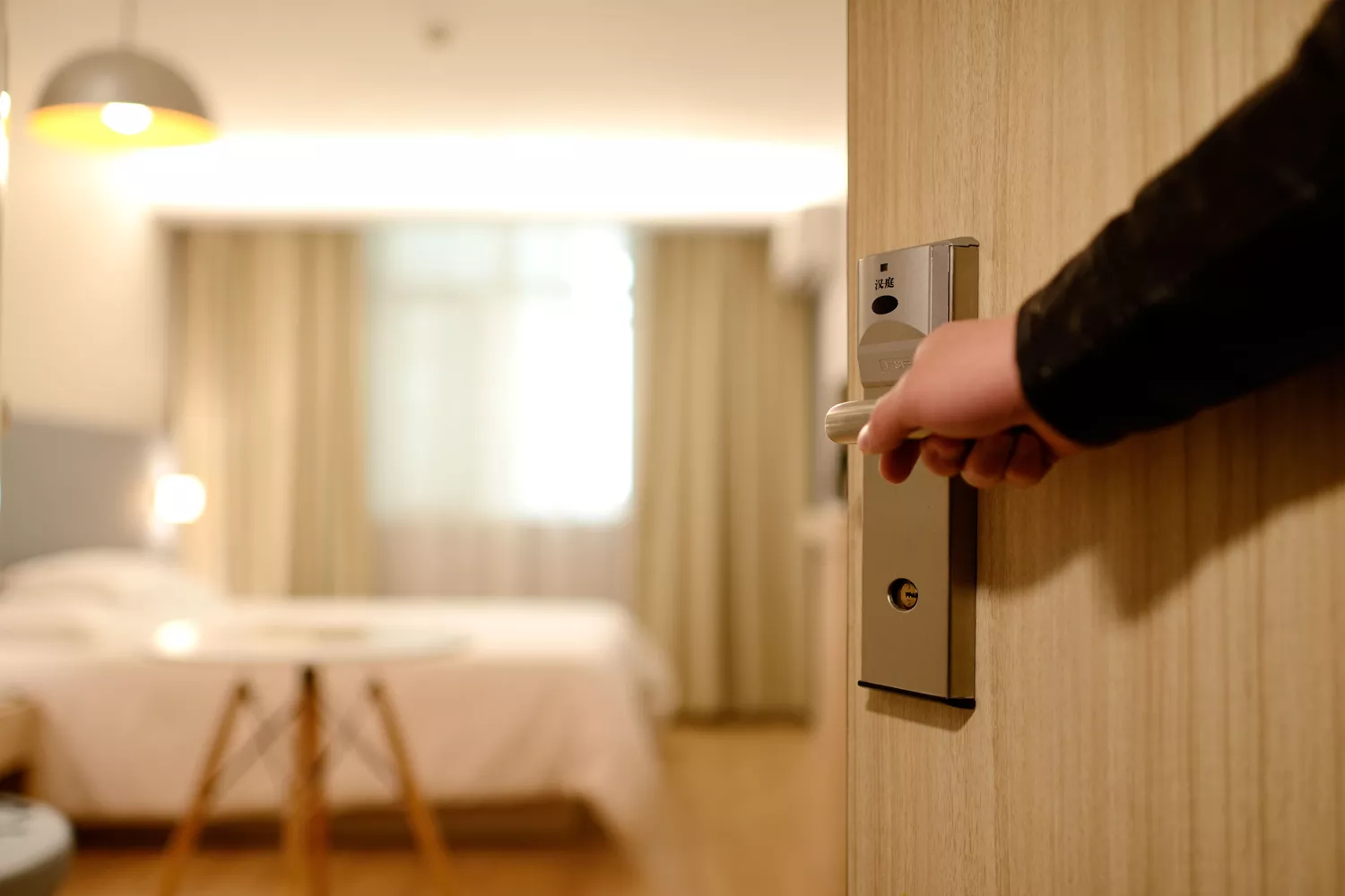 Una persona abre una habitación de hotel / PEXELS