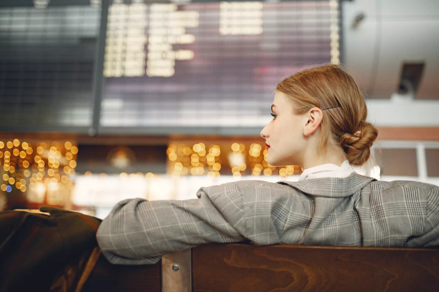 Una mujer espera a que salga el vuelo de una aerolínea / PEXELS