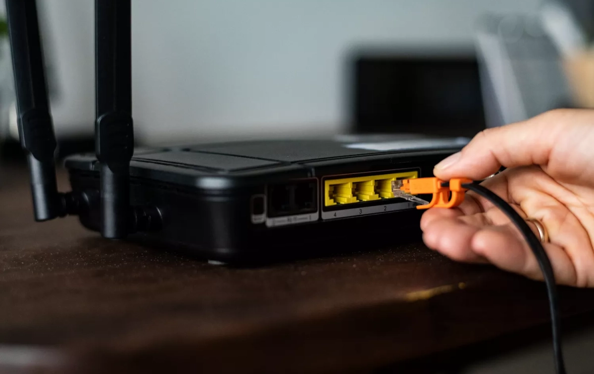 Una persona conecta un cable en su 'router' para mejorar el Wi-Fi / FREEPIK - @rawpixel.com