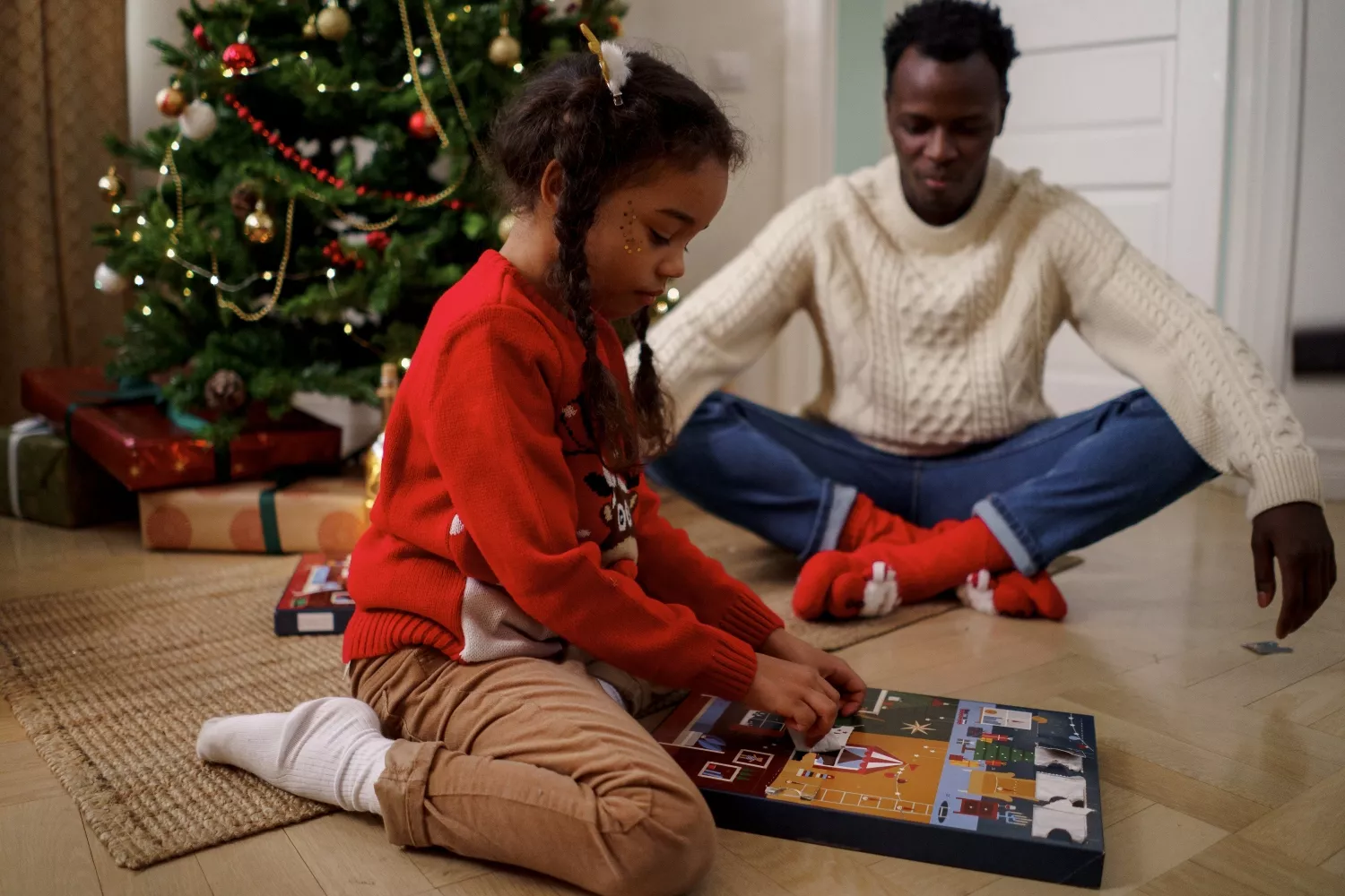 Un padre y su hija abren un calendario de Adviento / PEXELS