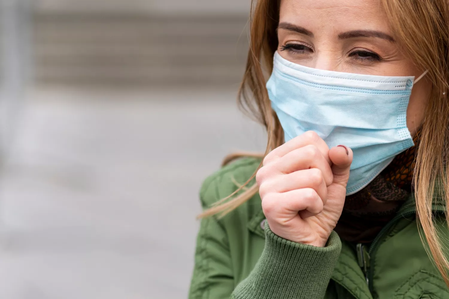 Una mujer con mascarilla padece síntomas de Covid / FREEPIK