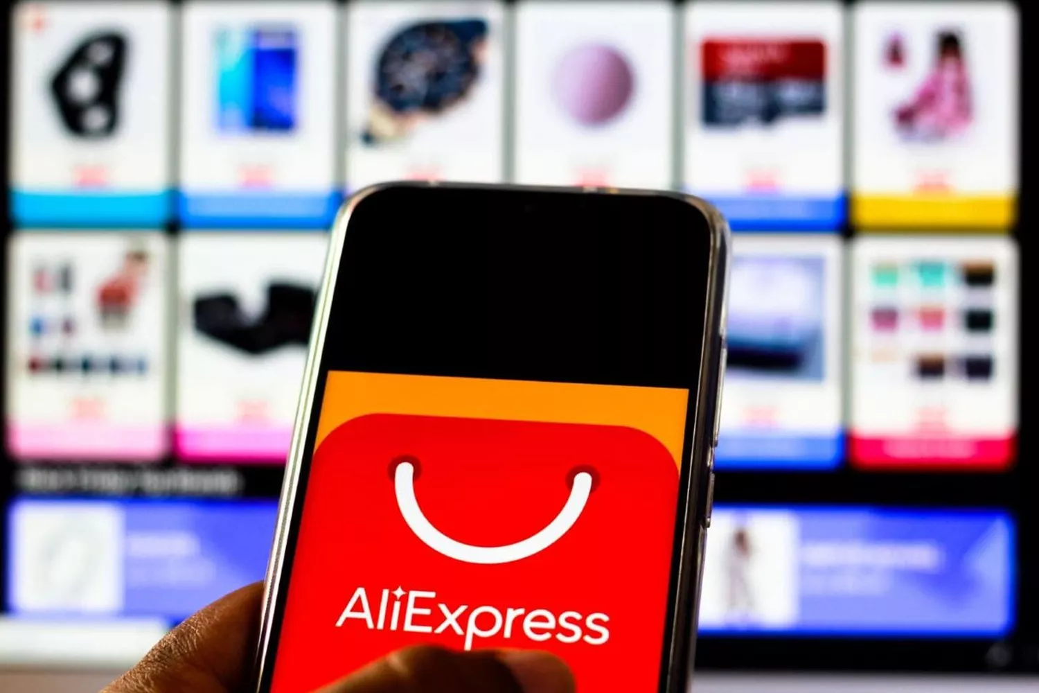 Una persona con AliExpress en el móvil y en el ordenador