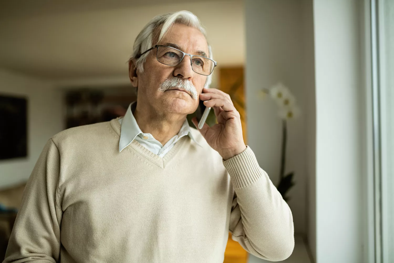 Un hombre mayor habla por teléfono con Glomark Home / FREEPIK