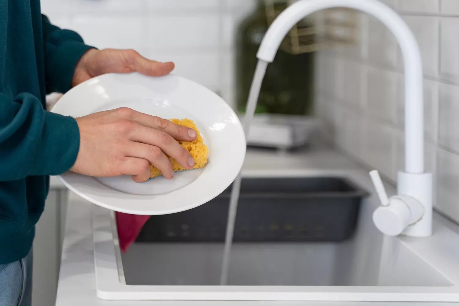 Una persona se dedica a fregar los platos con el lavavajillas de Aldi / FREEPIK