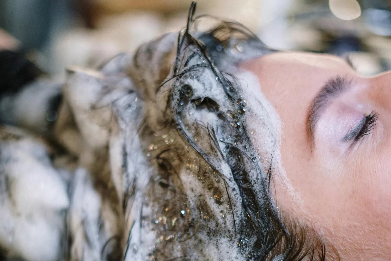 Una persona se limpia el cabello con uno de los champús de Mercadona/ PEXELS