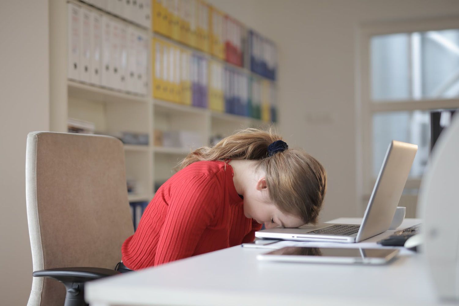 Una mujer visiblemente cansada después de trabajar muchas horas / PEXELS