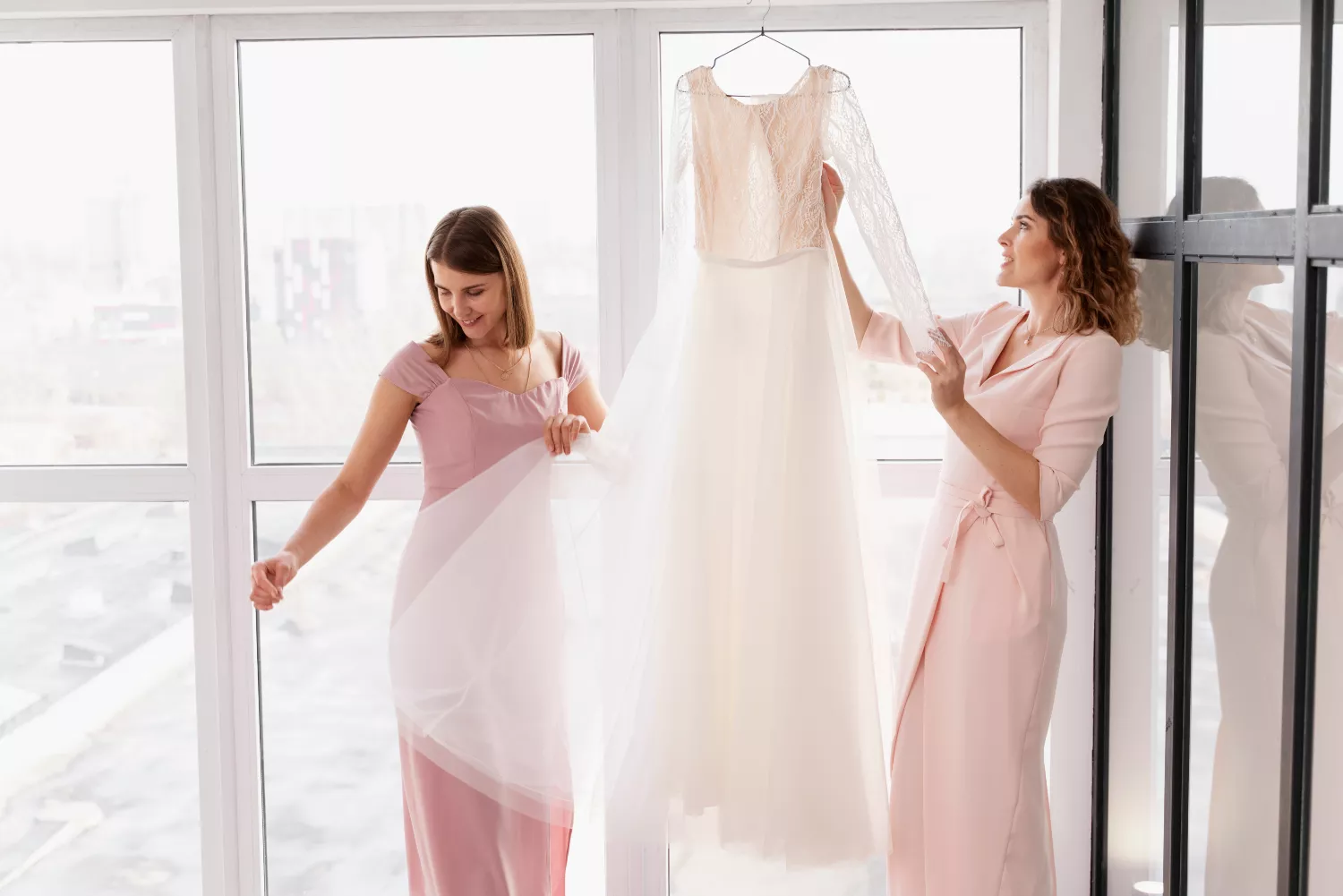 Dos chicas miran vestidos de bodas de segunda mano / FREEPIK