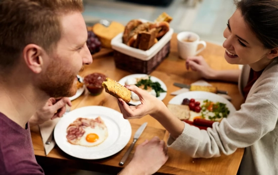 Una pareja disfruta de un desayuno / FREEPIK - @Drazen Zigic