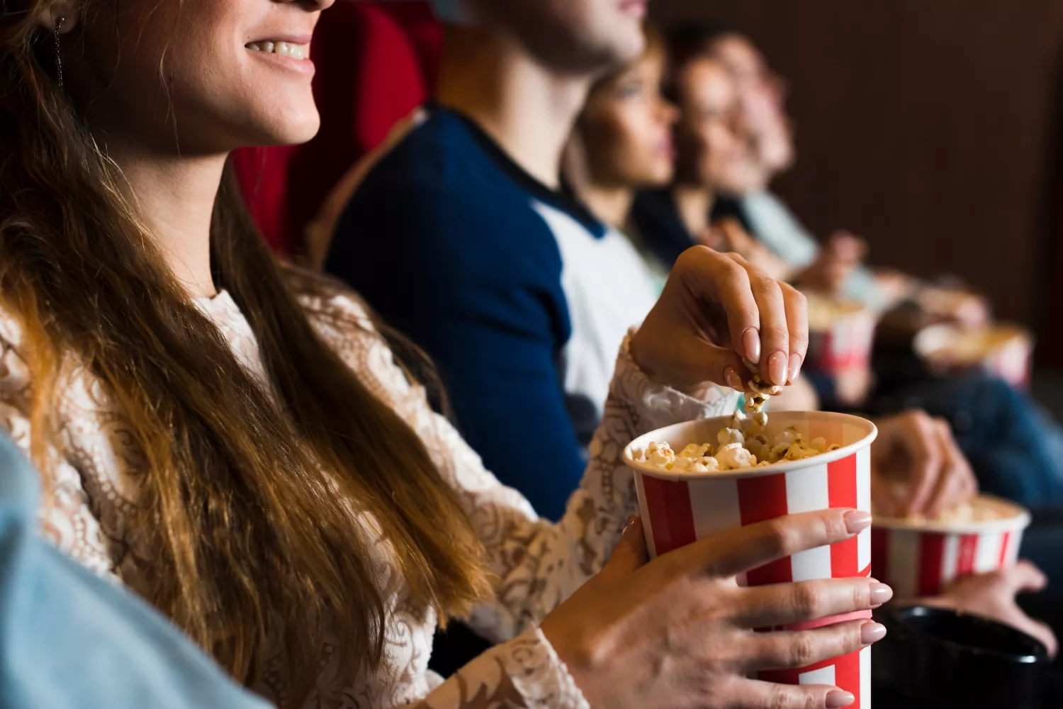 Varios asistentes disfrutan de una película en un cine / FREEPIK