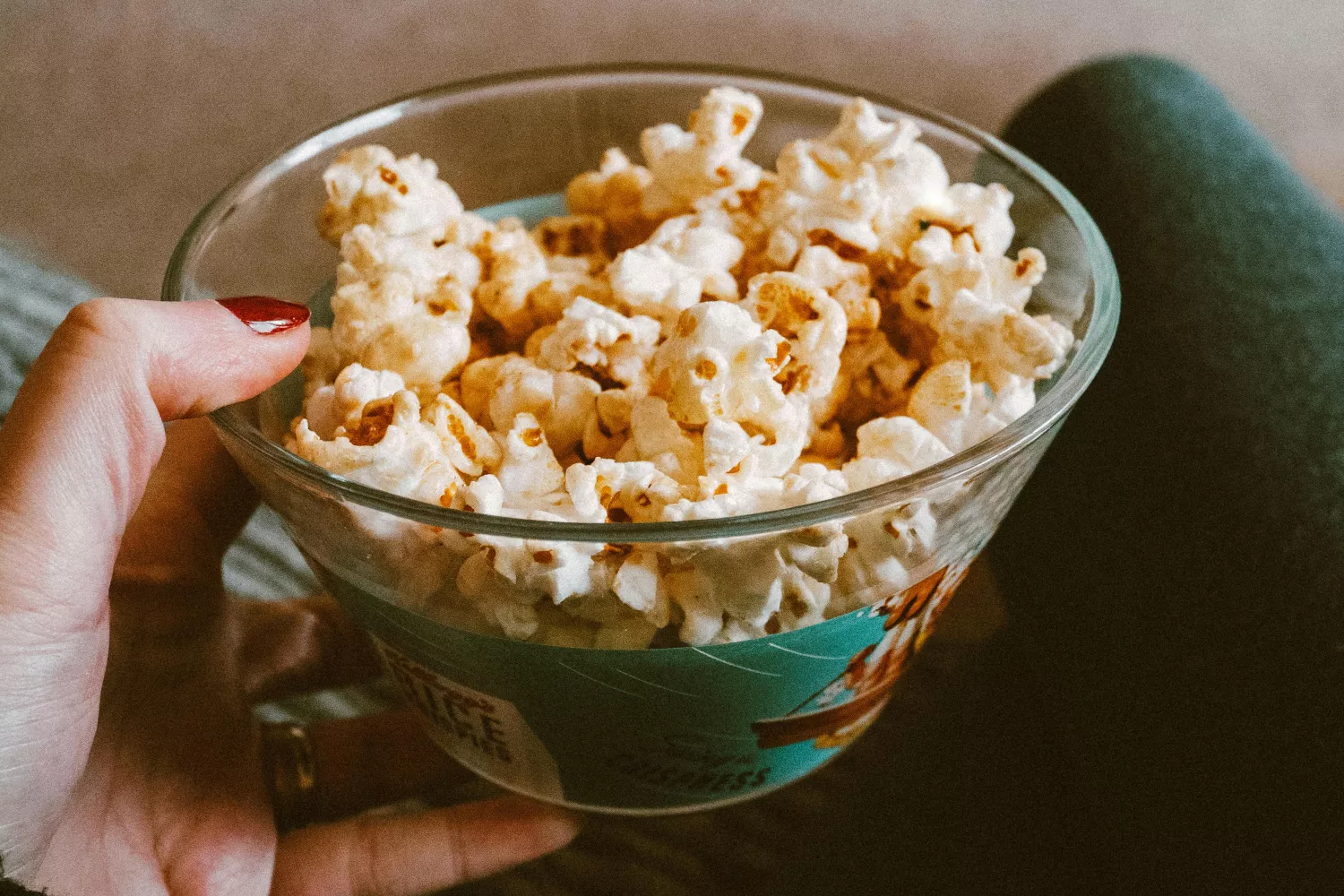 Una chica sostiene un bol de palomitas del cine / PEXELS