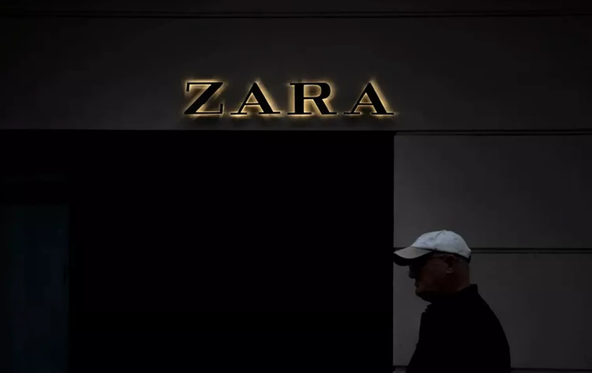 Una persona pasa por delante de una tienda de Zara / EFE