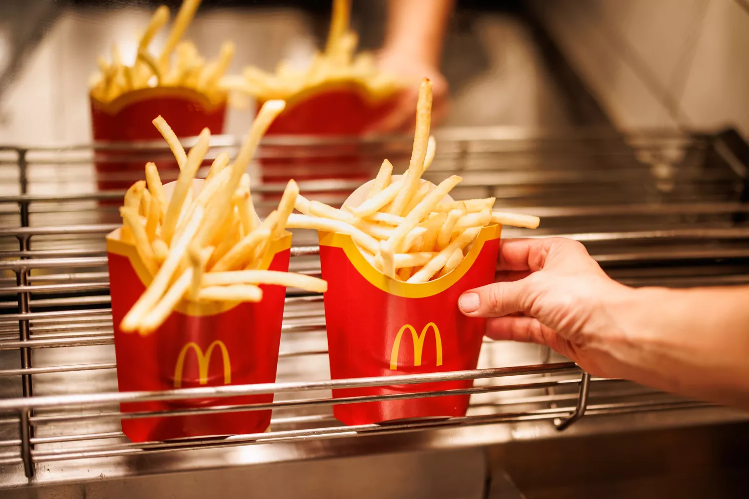 Un trabajador de McDonald's deja una caja de patatas fritas / Matthias Balk - DPA