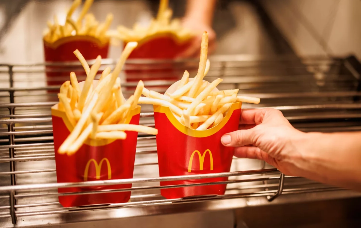 Un trabajador de McDonald's deja una caja de patatas fritas / Matthias Balk - DPA