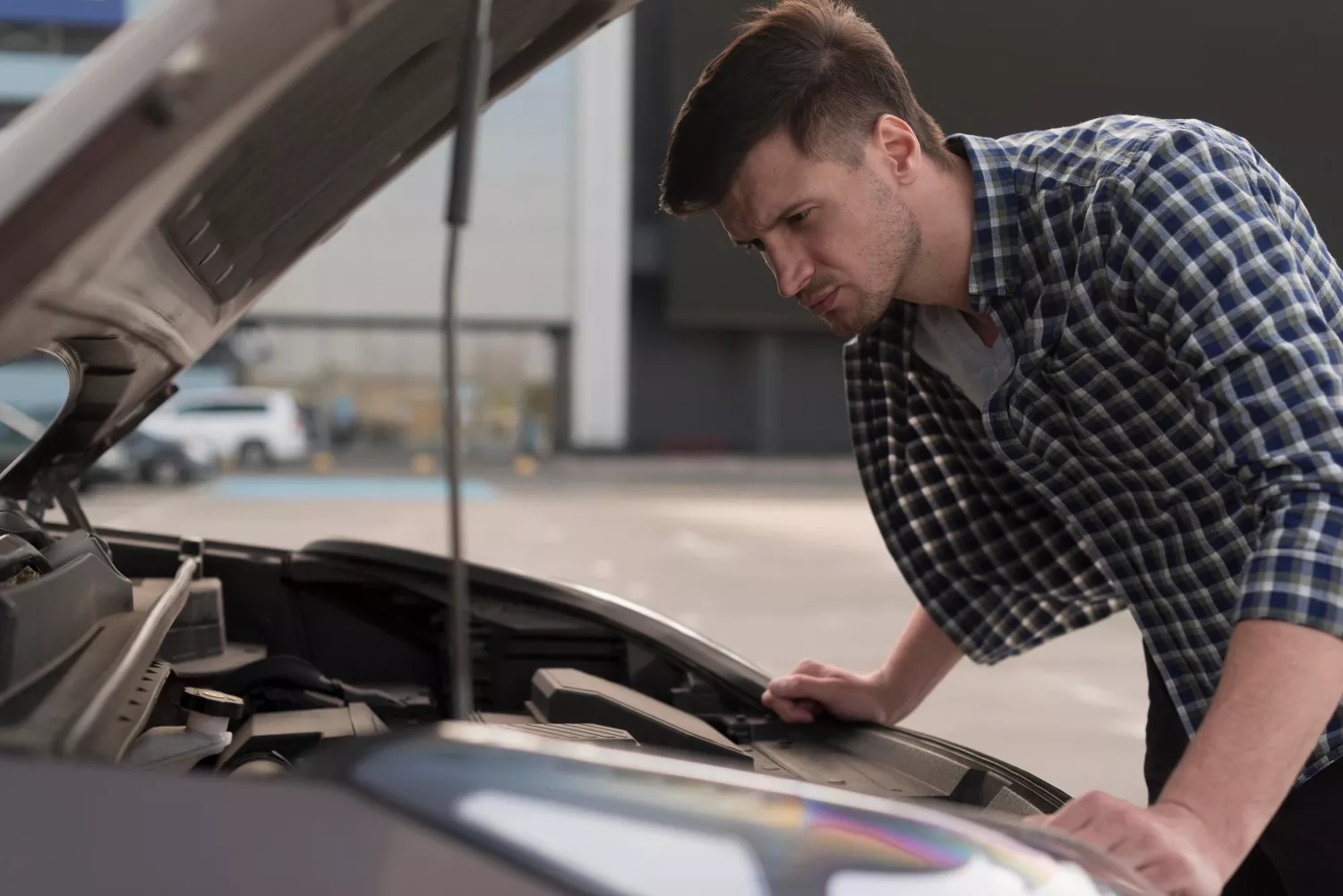 Un hombre revisa el estado de su coche comprado en I Cars Flex / FREEPIK