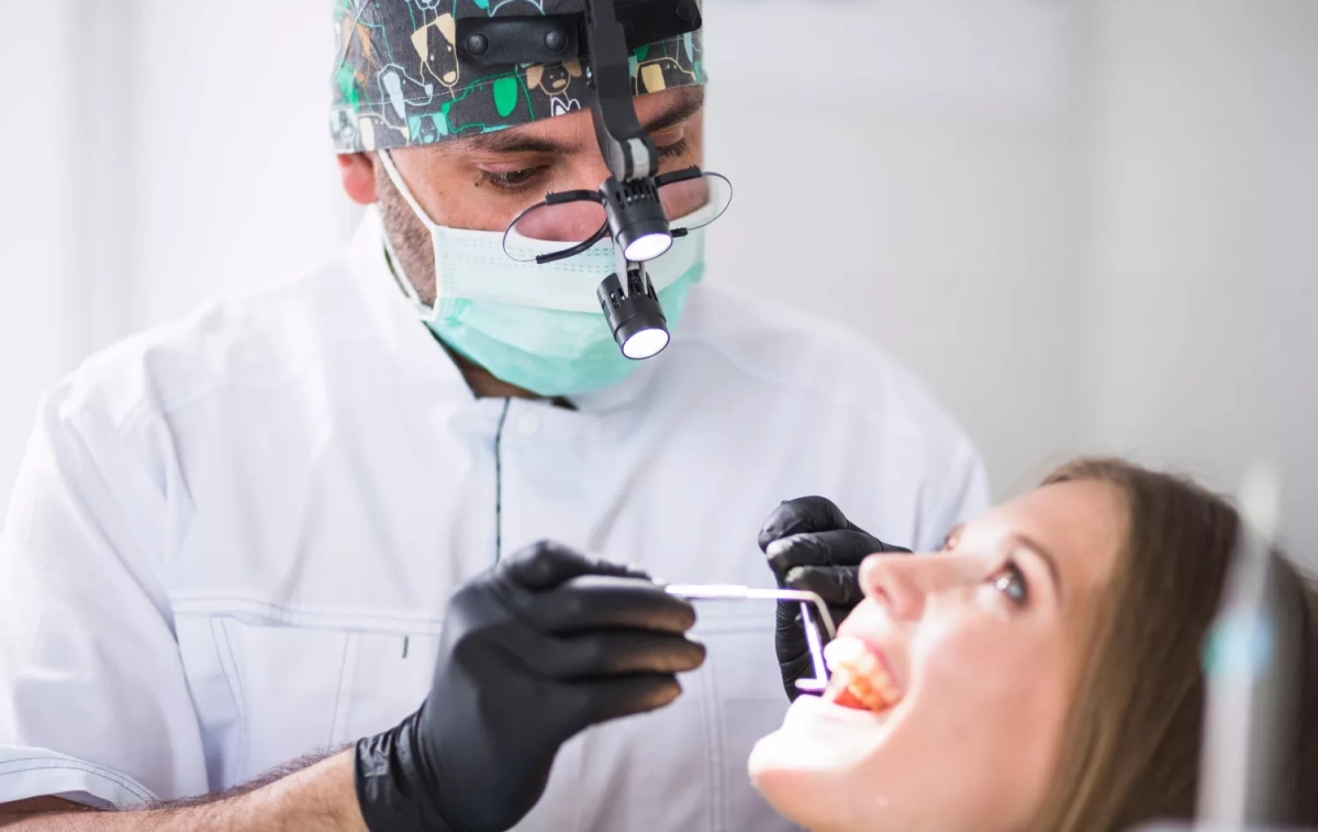 Un dentista revisa los dientes de una mujer / FREEPIK