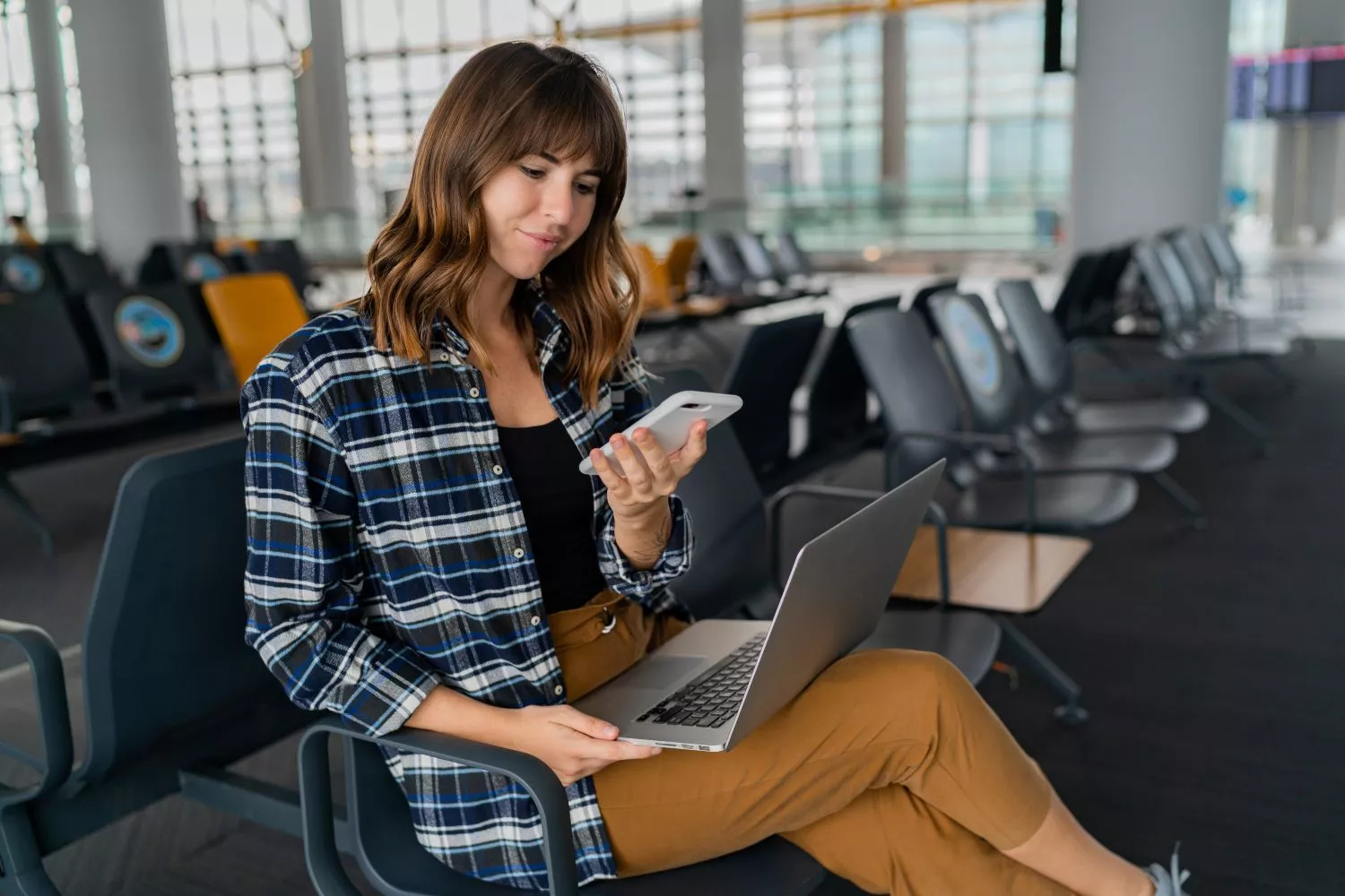 Una chica en el aeropuerto buscando vuelos / FREEPIK