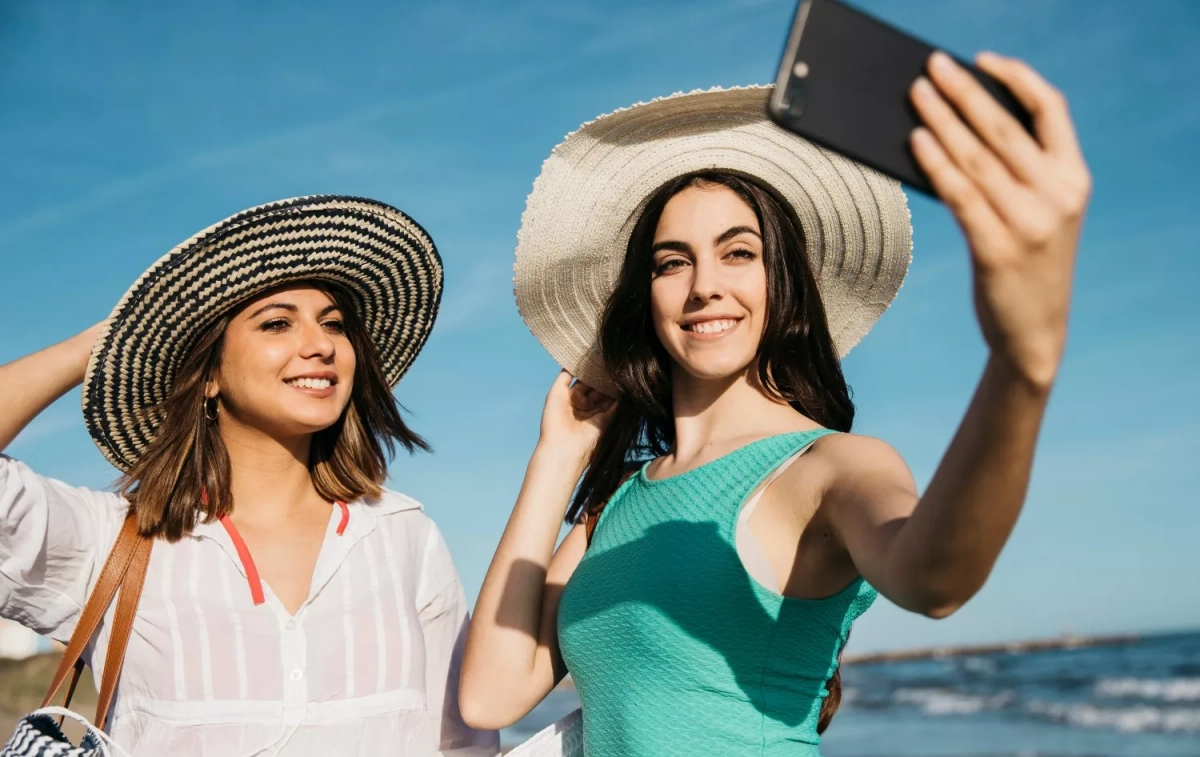 Dos chicas se toman un selfie en la playa / FREEPIK