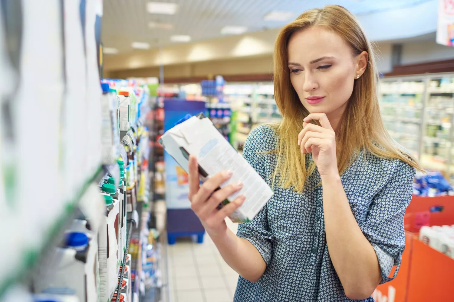 Una mujer observa el contenido de calcio de la leche / FREEPIK