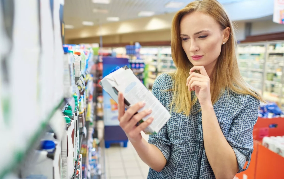 Una mujer observa el contenido de calcio de la leche / FREEPIK