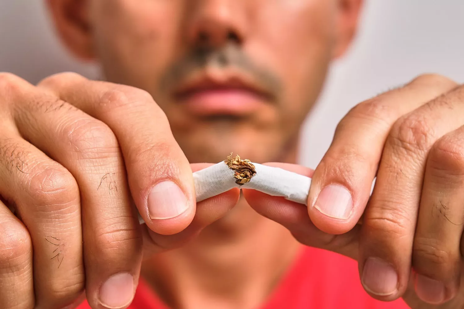 Una persona que quiere dejar de fumar rompe un cigarrillo / RUBER INTERNACIONAL