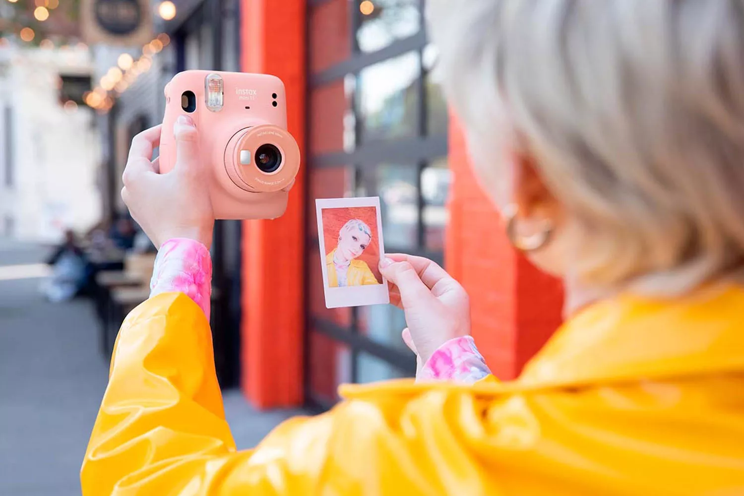 Una persona con una cámara instax mini 11 / FUJIFILM