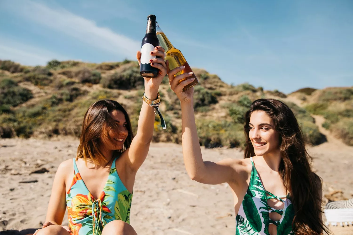 Dos chicas toman una playa en una cerveza / FREEPIK