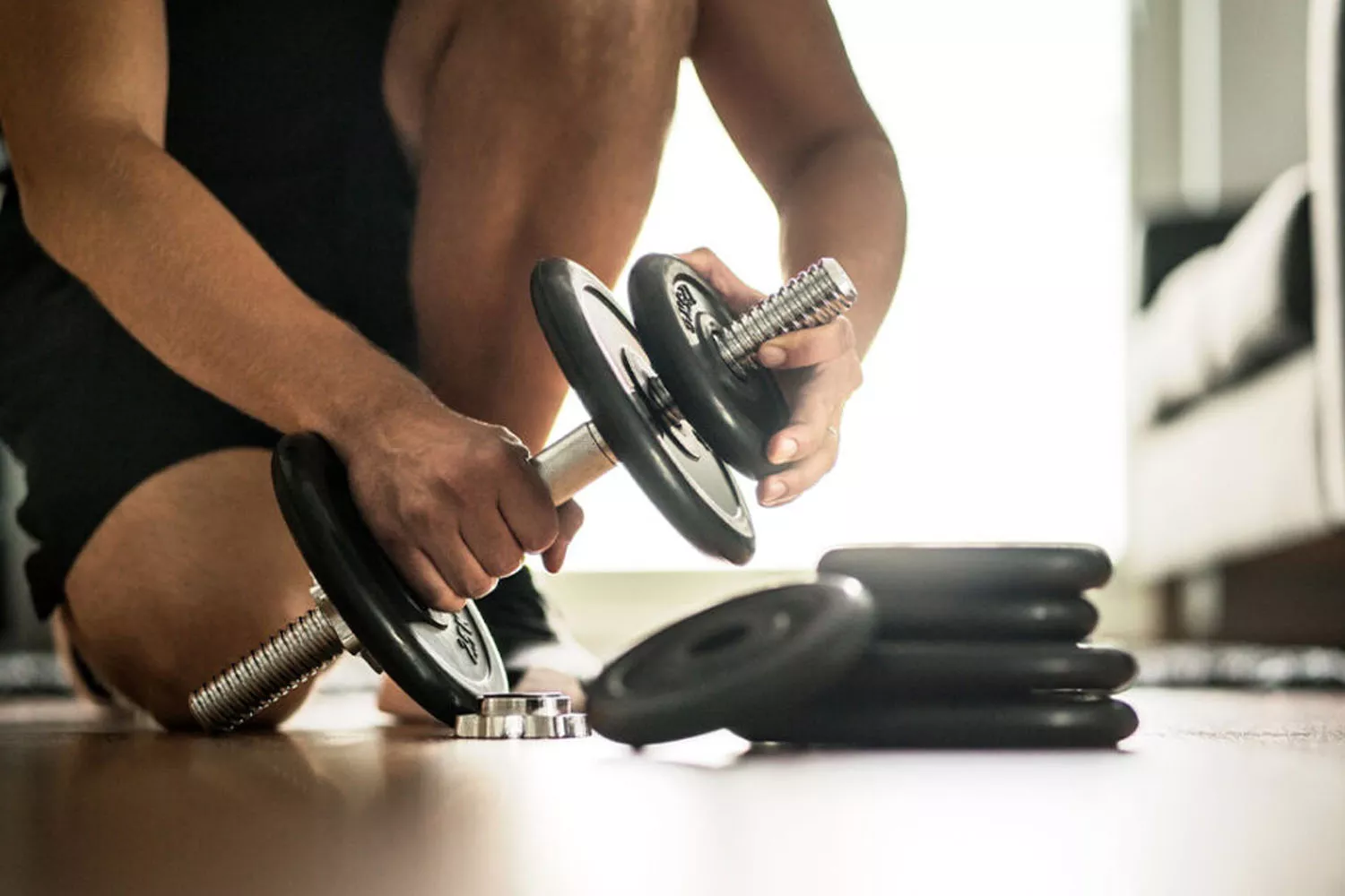 Una persona se prepara para hacer pesas en un gimnasio casero